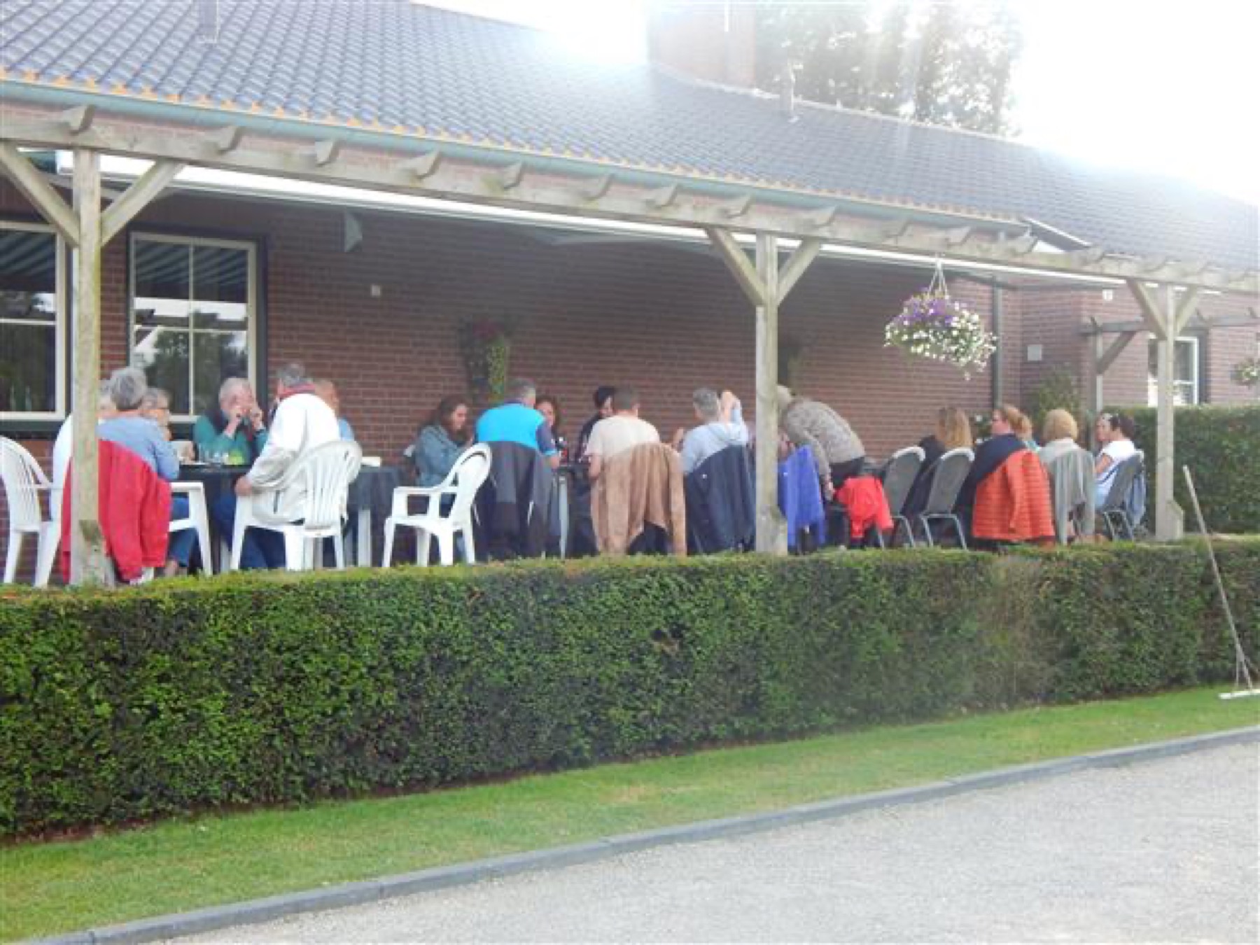 Gasten onder de overkapping bij de kantine