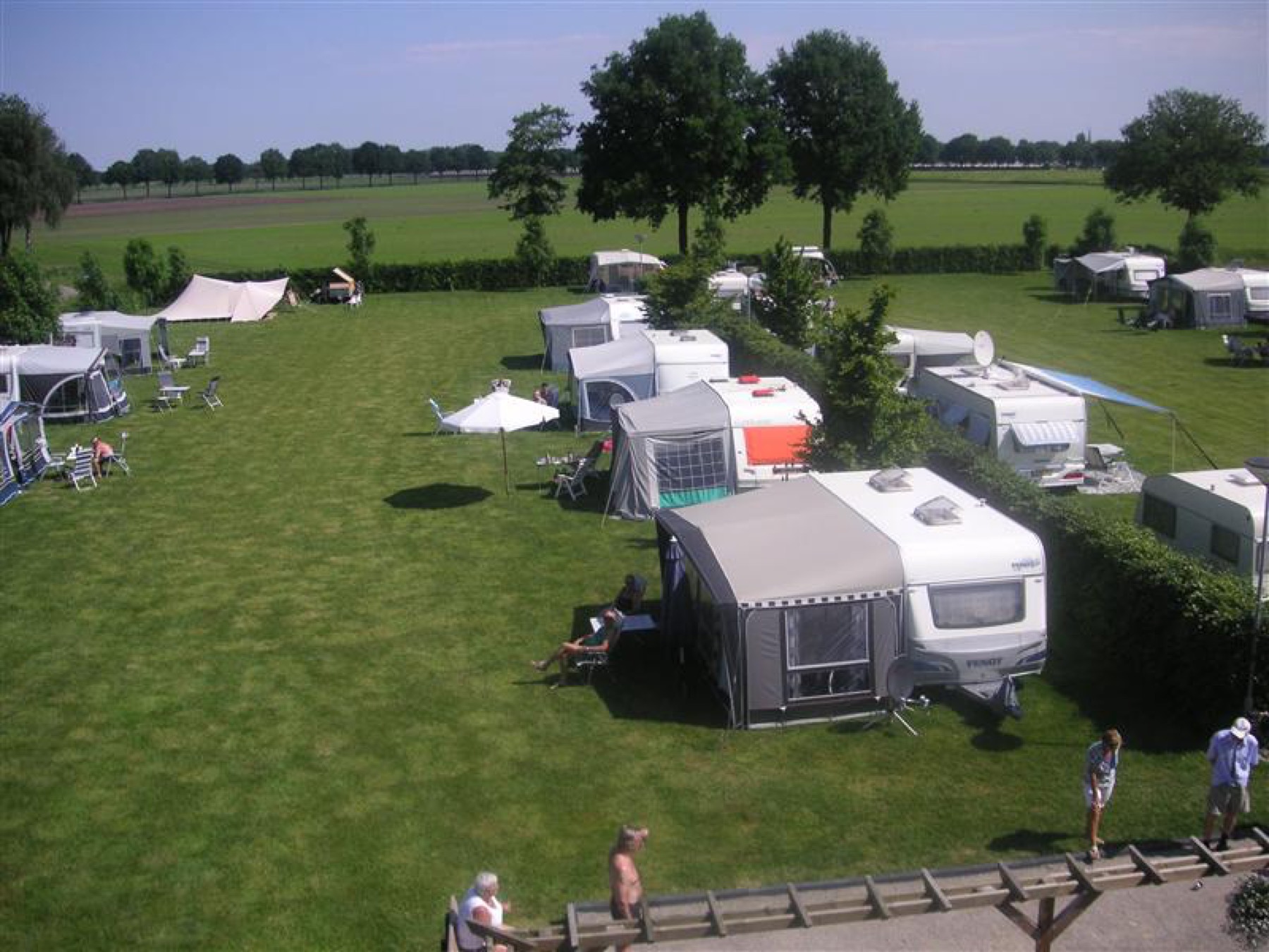 Caravans met voortenten op het grasveld van Camping de Peelfluiter, van bovenaf gezien